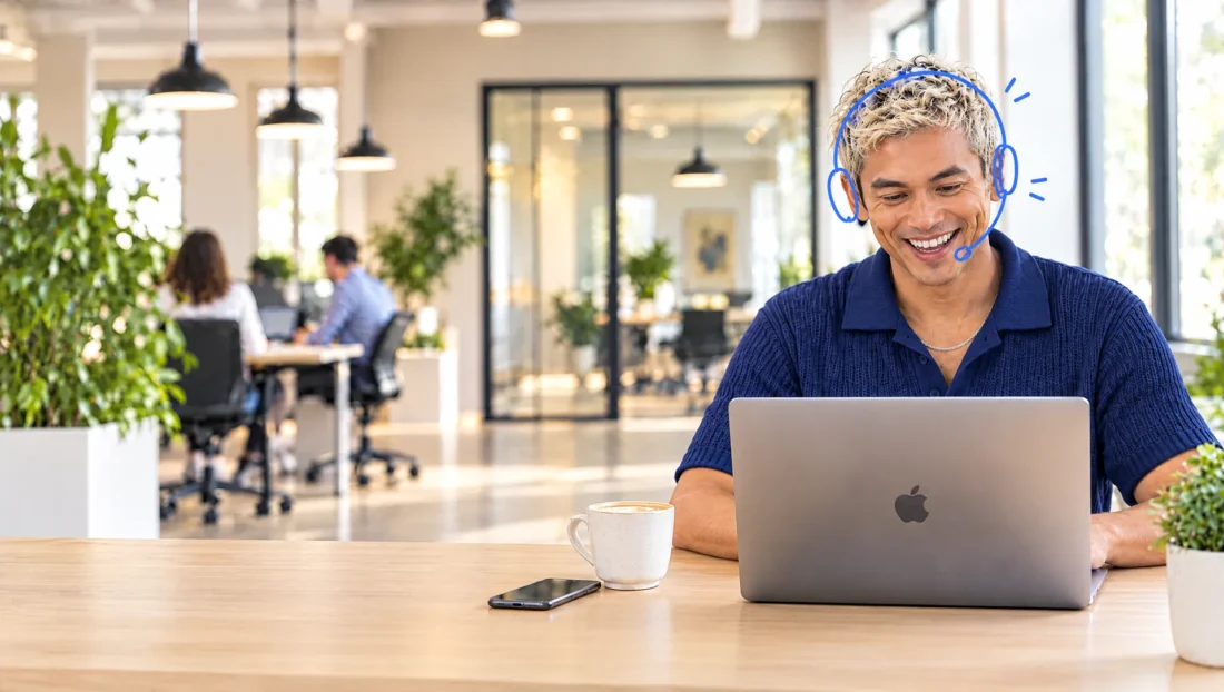 Lachende Credifin-medewerker met headset helpt een klant aan de telefoon terwijl hij het incassodossier op zijn MacBook verwerkt
